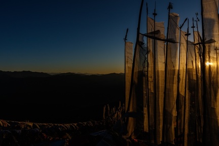 Poles of Praying Flags behind Sun